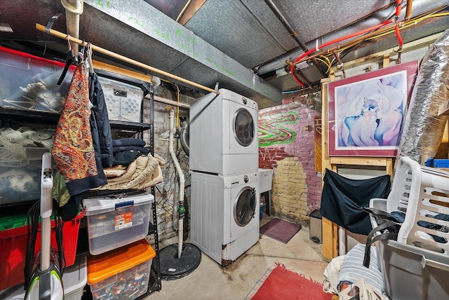 clothes washing area featuring stacked washer and clothes dryer