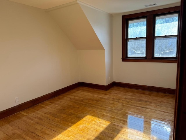 additional living space with hardwood / wood-style flooring