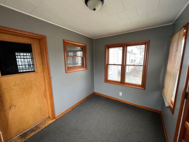 carpeted empty room featuring crown molding