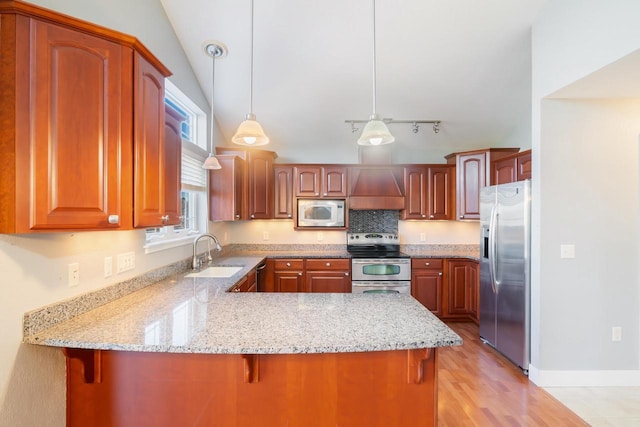 kitchen with sink, kitchen peninsula, decorative light fixtures, appliances with stainless steel finishes, and custom exhaust hood