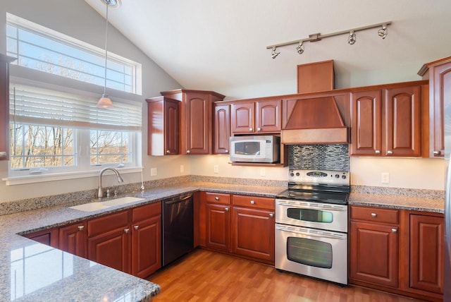 kitchen featuring light stone countertops, sink, pendant lighting, and appliances with stainless steel finishes