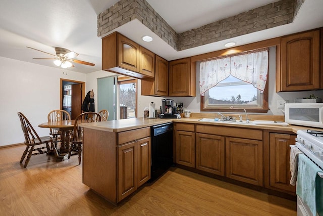 kitchen with white appliances, sink, ceiling fan, light wood-type flooring, and kitchen peninsula