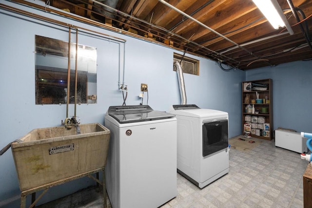 clothes washing area featuring separate washer and dryer and sink