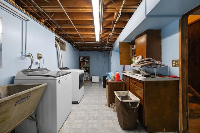 laundry room with washer and clothes dryer, cabinets, and sink