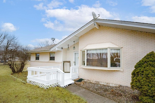 rear view of house featuring a yard and a deck