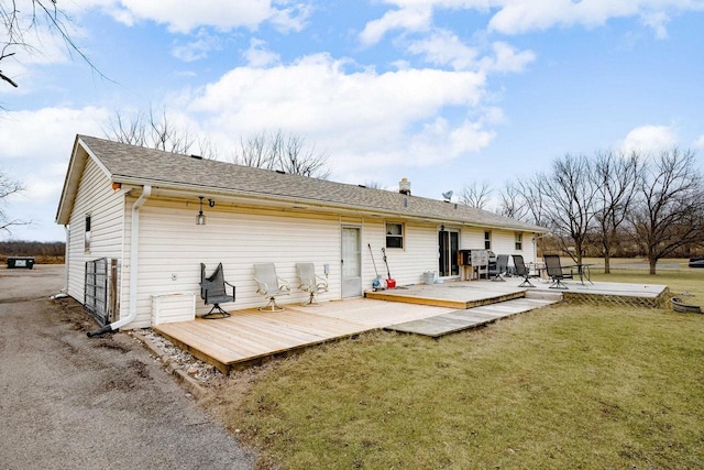 rear view of property featuring a yard and a wooden deck