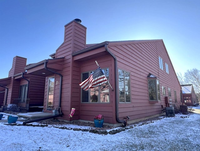 snow covered property with central AC