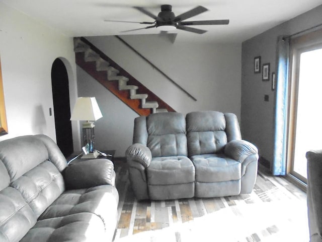 living room with plenty of natural light, ceiling fan, and light wood-type flooring