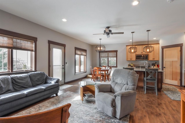 living room featuring ceiling fan, dark wood-type flooring, and sink