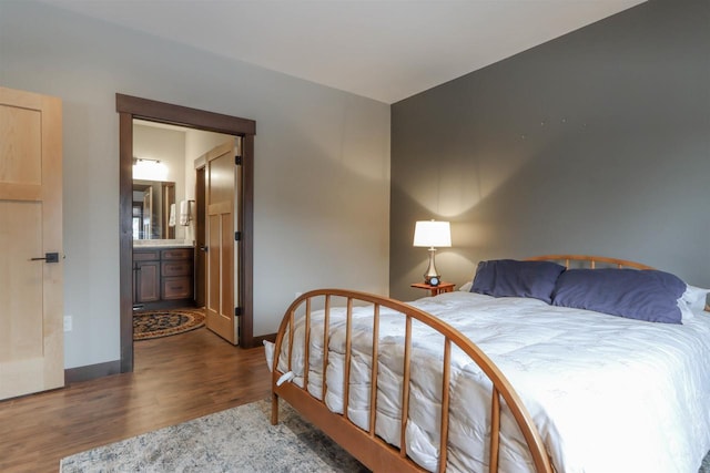 bedroom featuring ensuite bathroom and dark hardwood / wood-style floors