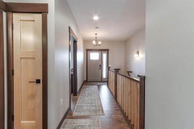 doorway featuring dark wood-type flooring and a notable chandelier