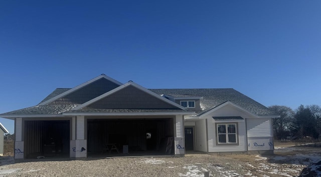 view of front of property featuring an attached garage and roof with shingles