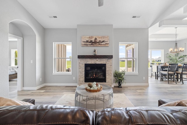 living room with wood finished floors, visible vents, and baseboards