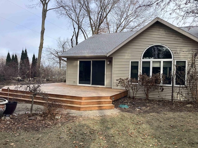 back of house with a wooden deck and a lawn