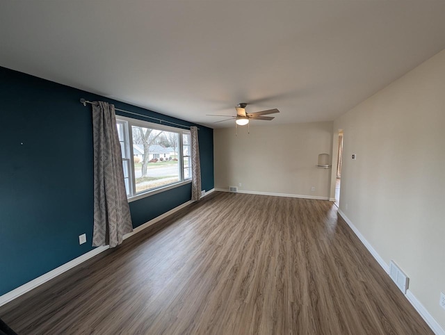 unfurnished room with dark hardwood / wood-style flooring and ceiling fan