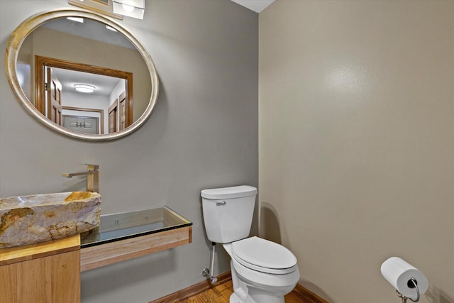 bathroom with hardwood / wood-style floors and toilet