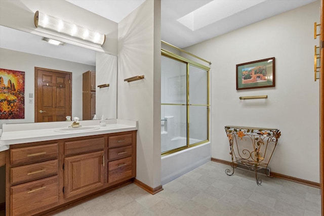 bathroom featuring combined bath / shower with glass door, vanity, and a skylight