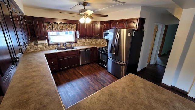 kitchen with stainless steel appliances, backsplash, dark hardwood / wood-style flooring, ceiling fan, and sink