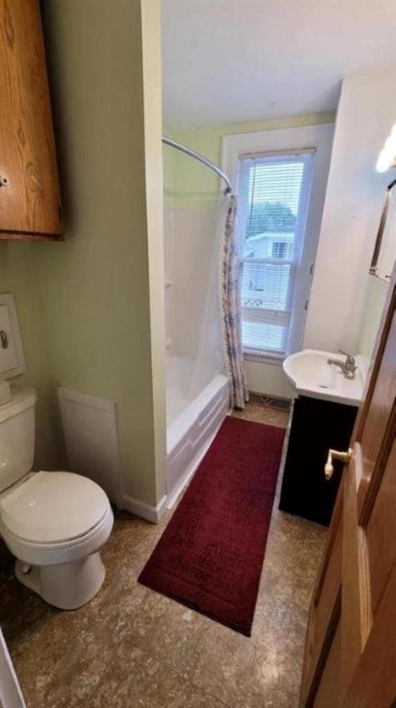 full bathroom with toilet, vanity, and shower / tub combo with curtain