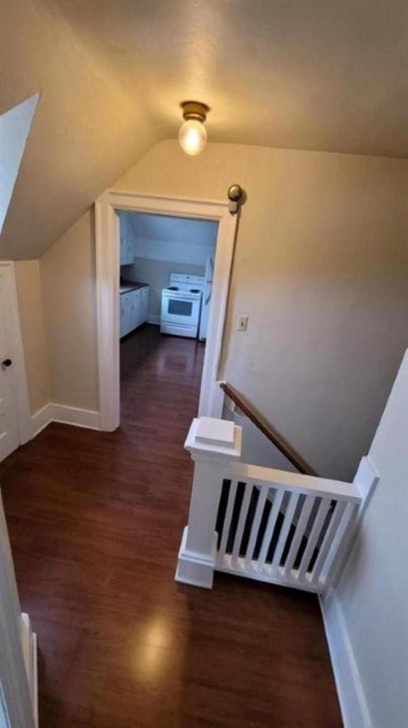 staircase featuring hardwood / wood-style floors and vaulted ceiling