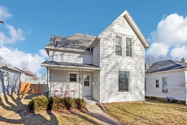 front facade with a porch, a front lawn, and cooling unit