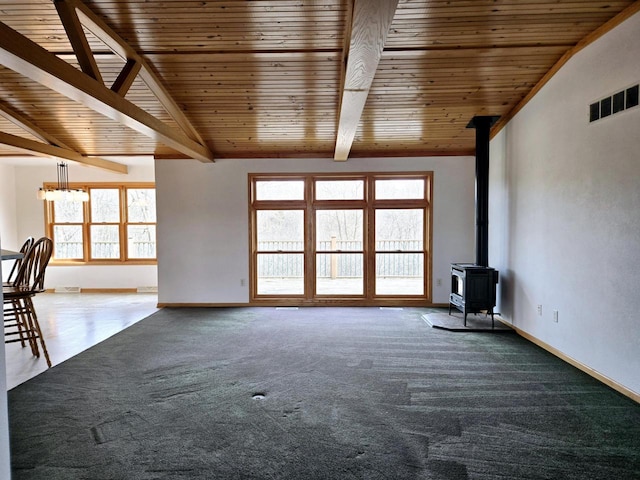 unfurnished living room featuring carpet floors, lofted ceiling with beams, a wood stove, and wooden ceiling