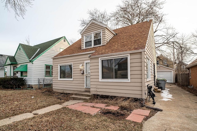 back of property featuring a garage and an outbuilding