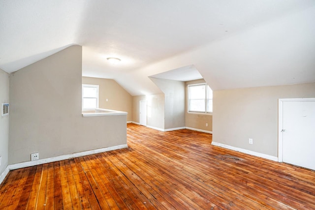 additional living space with light hardwood / wood-style floors and vaulted ceiling