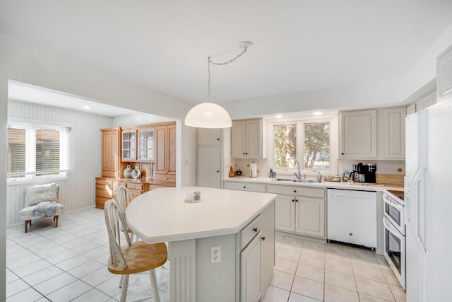 kitchen with sink, a center island, hanging light fixtures, white appliances, and light tile patterned floors