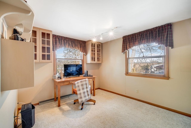 carpeted home office featuring track lighting