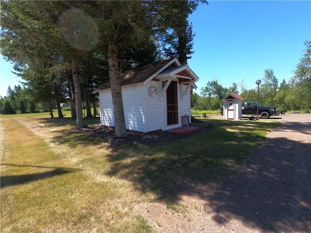 view of side of home featuring a lawn and a storage unit