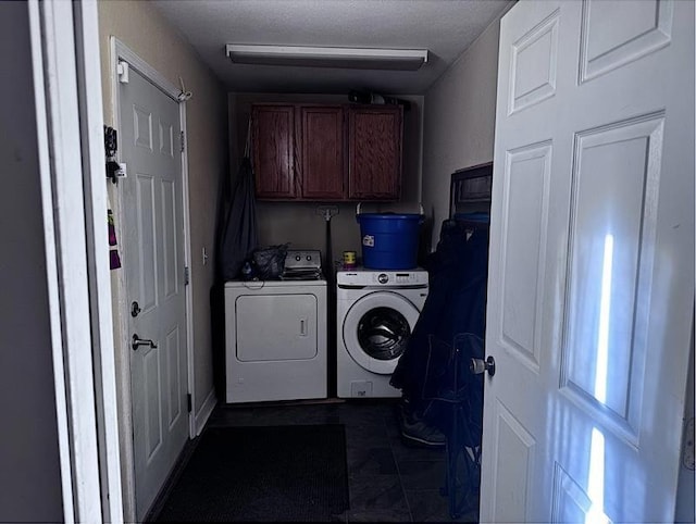 clothes washing area featuring washing machine and clothes dryer and cabinets