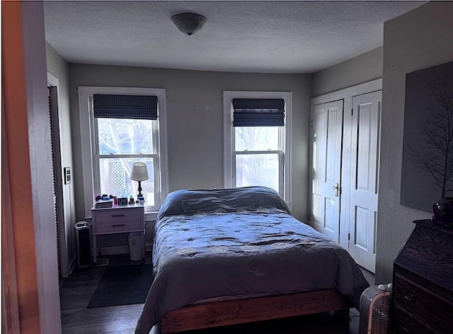 bedroom with a textured ceiling, a closet, and hardwood / wood-style flooring