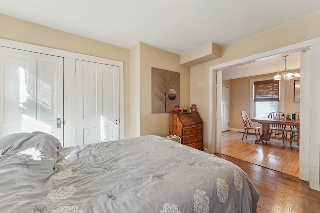 bedroom featuring hardwood / wood-style floors, a closet, and an inviting chandelier