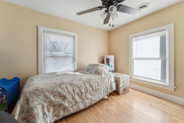 bedroom featuring a textured ceiling, ceiling fan, and hardwood / wood-style floors