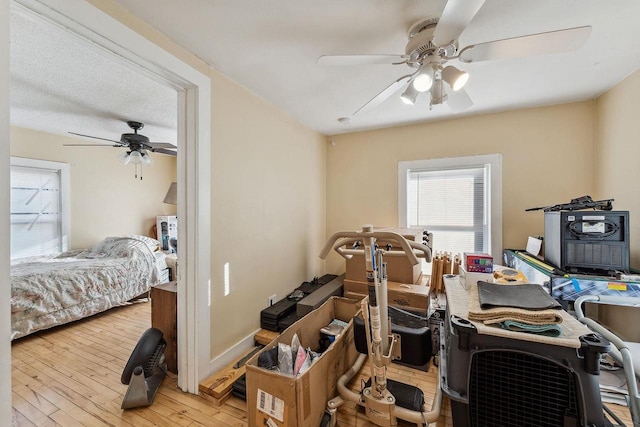 interior space with ceiling fan, a textured ceiling, and light wood-type flooring