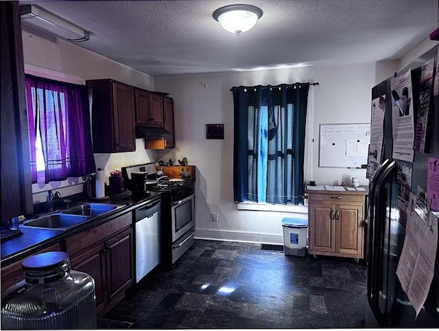 kitchen featuring sink, a textured ceiling, and stainless steel appliances