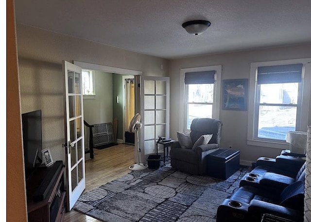 living room featuring hardwood / wood-style flooring, a textured ceiling, and french doors