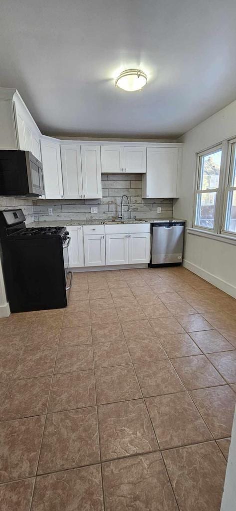 kitchen with light tile patterned flooring, white cabinetry, sink, and appliances with stainless steel finishes