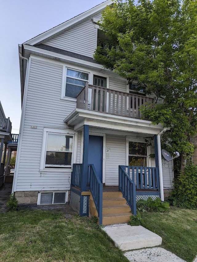 view of front of property with a balcony and a front lawn