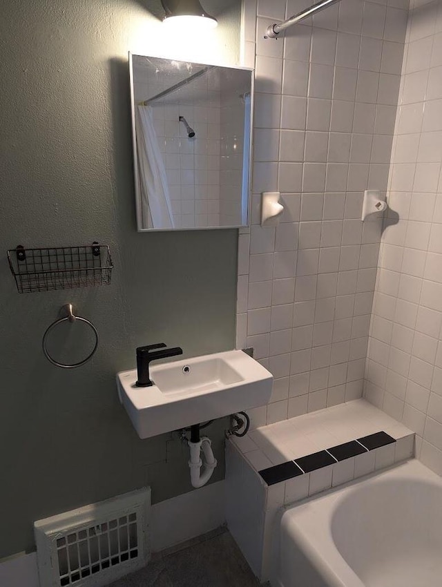 bathroom featuring shower / bath combo with shower curtain and sink