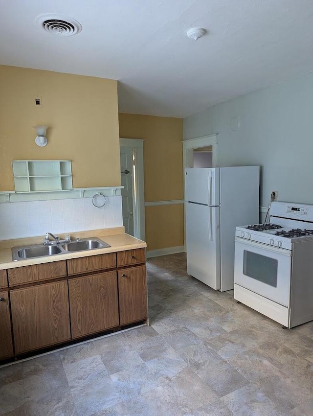 kitchen with decorative backsplash, sink, and white appliances