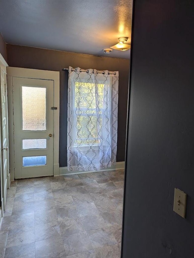 foyer entrance with a textured ceiling