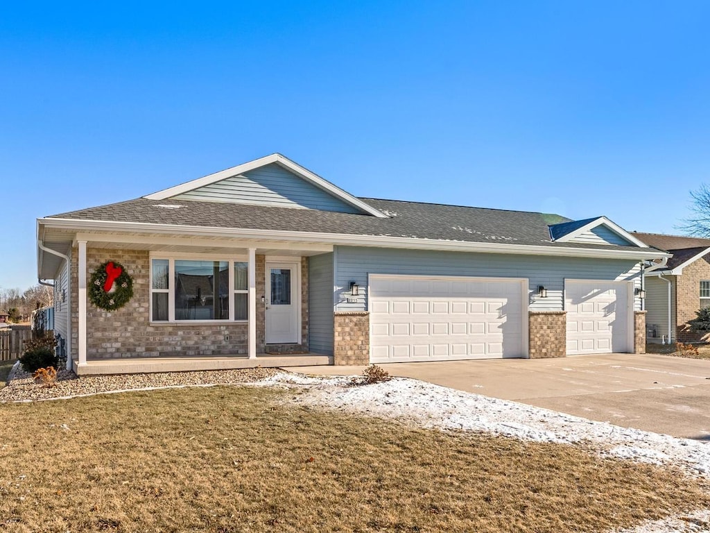 ranch-style house featuring a garage and a front lawn