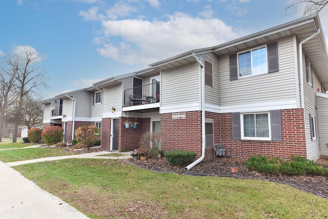 view of front of home with a front yard and a balcony