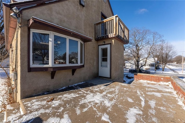 snow covered property with a balcony