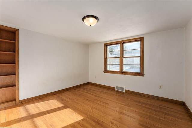 unfurnished room with hardwood / wood-style flooring