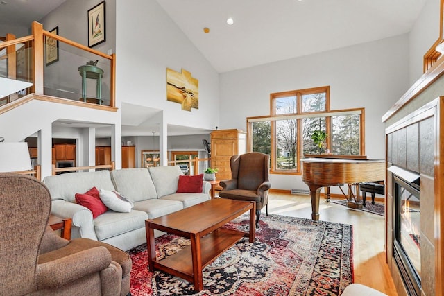 living room with light wood-type flooring and high vaulted ceiling