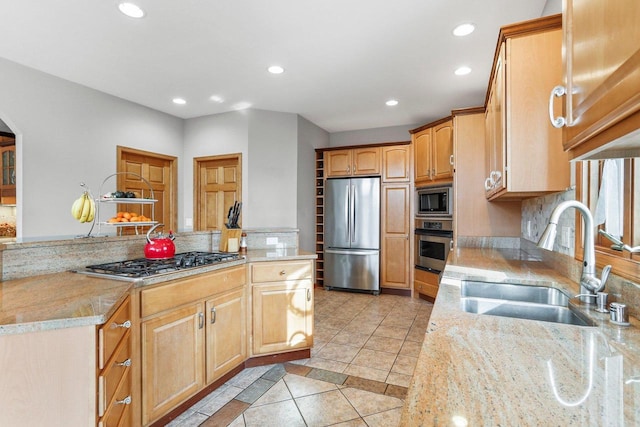 kitchen with stainless steel appliances, kitchen peninsula, light tile patterned floors, light stone counters, and sink