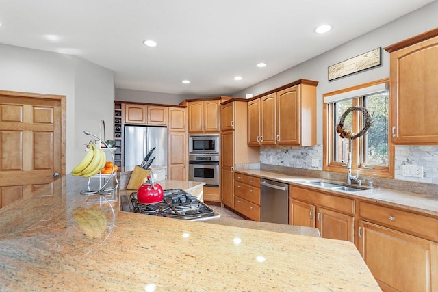 kitchen with appliances with stainless steel finishes, decorative backsplash, light stone counters, and sink